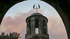 Zwei Störche sitzen auf dem Turm einer ausgebrannten Kirche neben Alexandroupolis