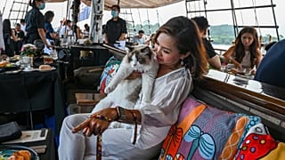 A visitor sits with her cat on the Royal Albatross, a luxury tall ship that hosts sailing and dining experiences around the waters of Singapore with pets allowed.