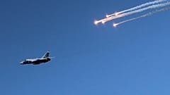 Kırım'ın Sivastopol kentinde 27 Temmuz 2014 tarihinde Donanma Günü kutlamaları kapsamında düzenlenen hava gösterisi sırasında Rus Ordusuna ait bir savaş uçağının yanında işaret fişekleri atılıyor.