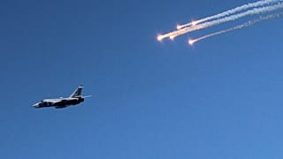 Kırım'ın Sivastopol kentinde 27 Temmuz 2014 tarihinde Donanma Günü kutlamaları kapsamında düzenlenen hava gösterisi sırasında Rus Ordusuna ait bir savaş uçağının yanında işaret fişekleri atılıyor.