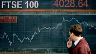 نمایشگری که عملکرد شاخص سهام FTSE 100 بریتانیا را در لندن نشان می دهد