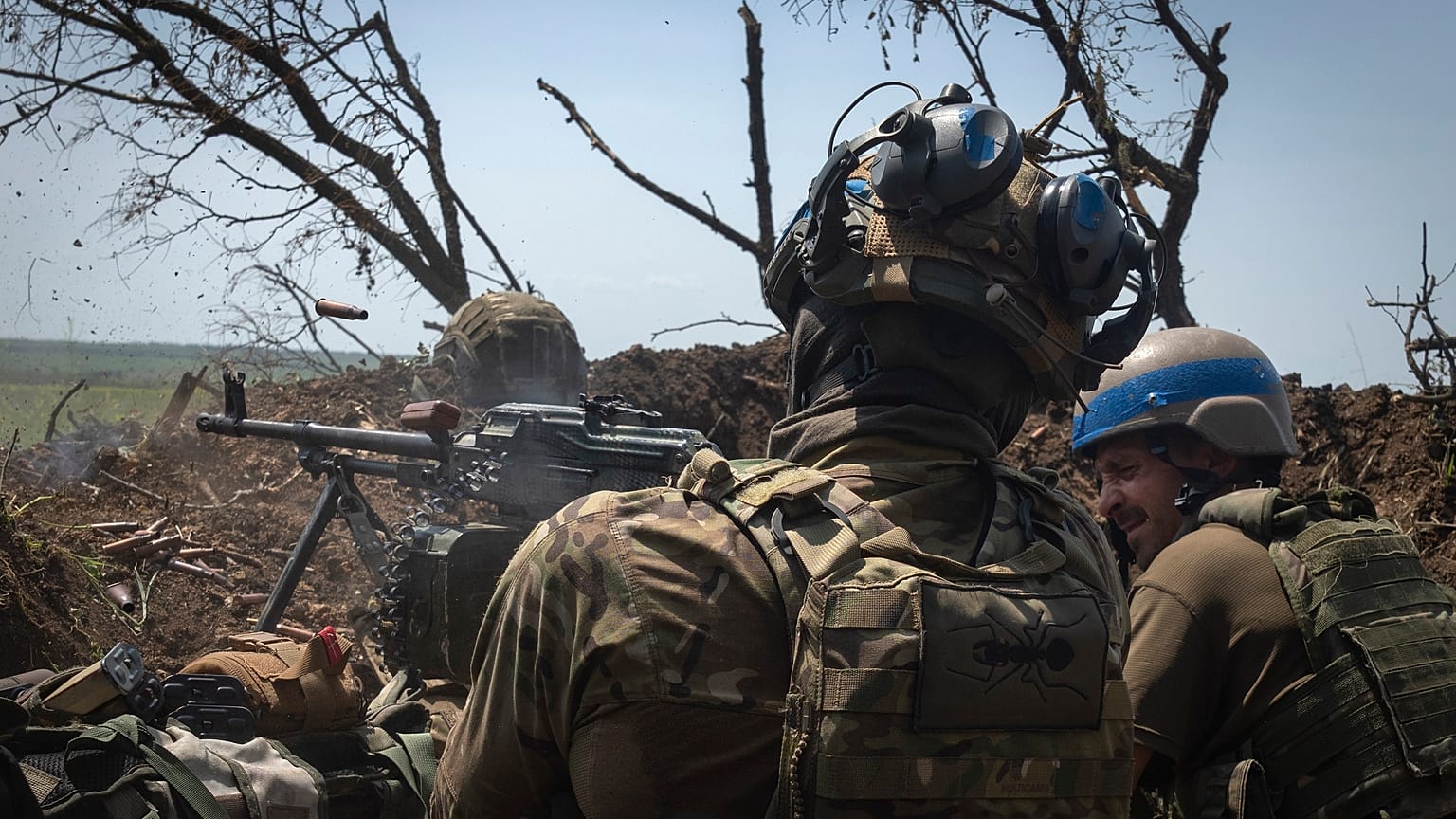 Ukrainian soldiers fire toward Russian position from a trench on the frontline in Zaporizhzhia region,