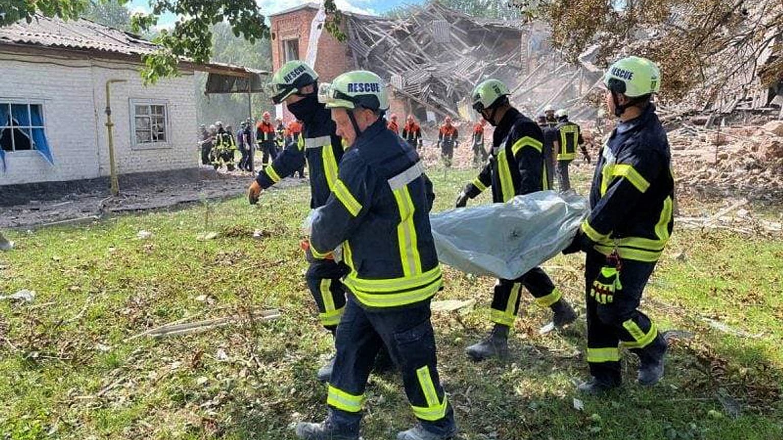 Сотрудники ГСЧС выносят тело жертвы атаки "Шахеда", Ромны, Сумская область, 23 августа 2023.