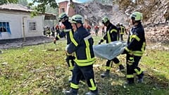 Сотрудники ГСЧС выносят тело жертвы атаки "Шахеда", Ромны, Сумская область, 23 августа 2023.