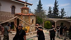Пожарные тушат огонь в монастыре Святой Параскевы Пятницы в греческом городе Ахарне, 23 августа 2023 г.