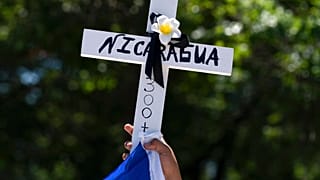 Manifestantes alzan una cruz con la palabra Nicaragua