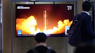 Dél-koreai járókelők nézik egy északi rakétakilövés képeit