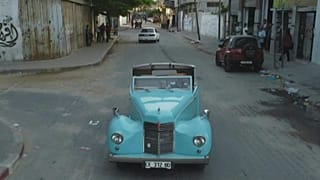 الفلسطيني منير الشندي يقود سيارة قديمة فاخرة.