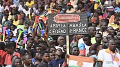 Homem segura cartaz onde se lê: "Abaixo França, abaixo a CEDEAO", Nyamei, 26 de agosto