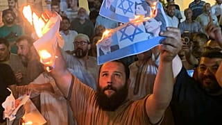 Manifestantes queimam fotos do ministro israelita dos Negócios Estrangeiros e da sua homóloga líbia, nas ruas de Trípoli, na Líbia