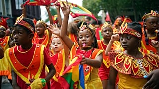 Participants dance during the Children's Day Parade, part of the Notting Hill Carnival celebration in west London
