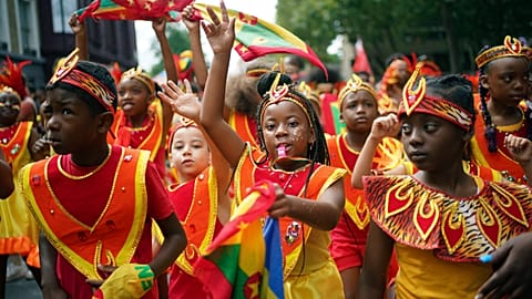 Participants dance during the Children's Day Parade, part of the Notting Hill Carnival celebration in west London