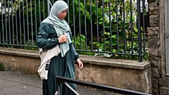 تلميذة ترتدي العباءة في طريقها إلى المدرسة