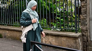 تلميذة ترتدي العباءة في طريقها إلى المدرسة