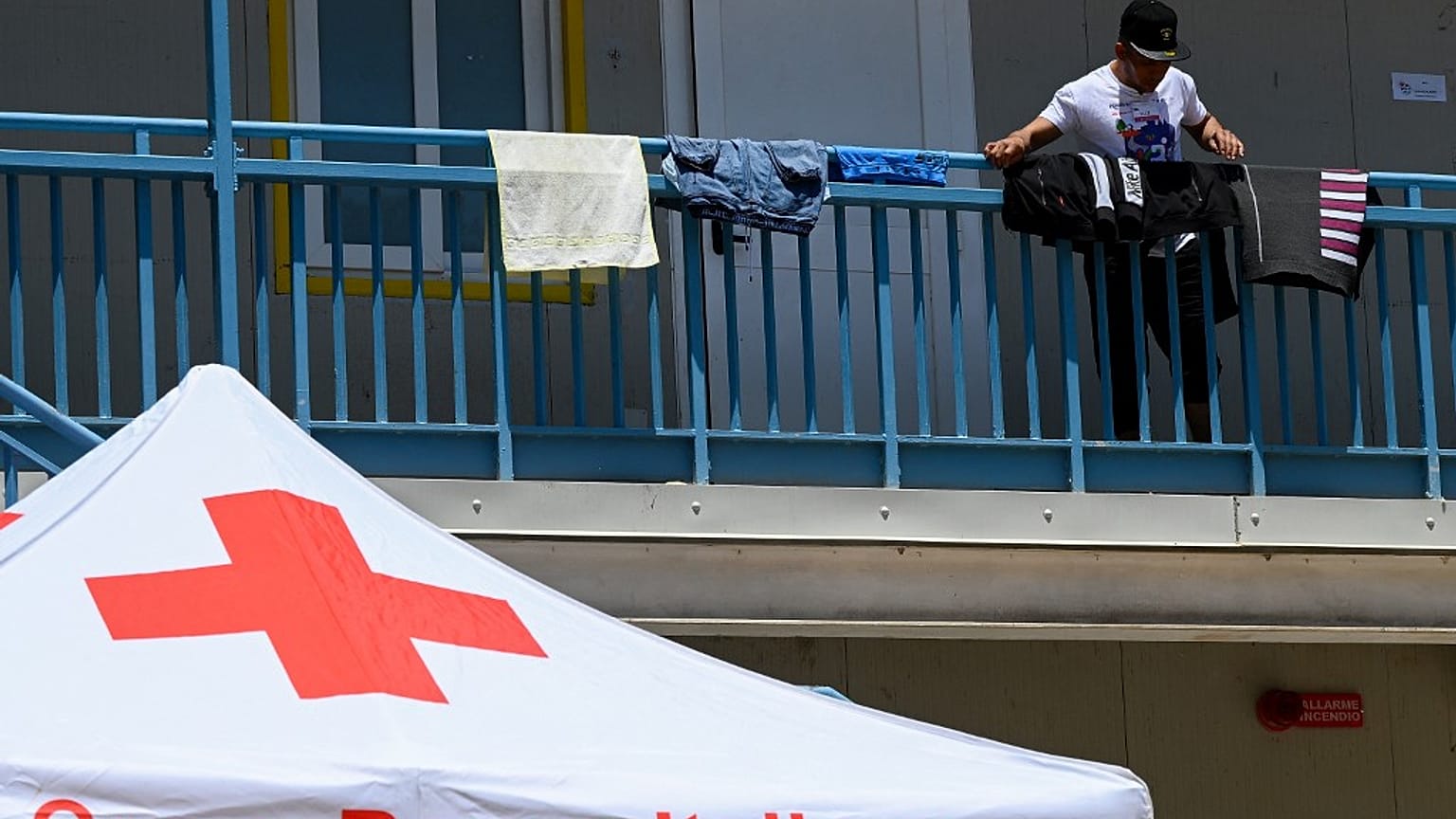 Un migrante pone a secar su ropa el 7 de junio de 2023 en el punto de acceso de inmigrantes en la isla de Lampedusa.