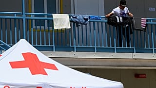Un migrant sèche son linge au centre d'accueil géré par la Croix-Rouge italienne, le 7 juin 2023, sur l'île de Lampedusa.