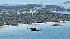  Eine mit Wärmebildkameras und einem ausgeklügelten Frühwarnsystem ausgestattete Langstreckendrohne patrouilliert über dem Strand von Kavouri und dem nahe gelegenen Waldgebiet im Süden von Athen, Griechenland.