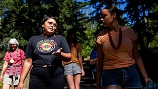 Serina Fast Horse, of Sicangu Lakota & Blackfeet Tribes (L) talks with Jacy Bowles, of Xicana and Diné descent, during the 2023 Tribal Climate Camp in Washington state.