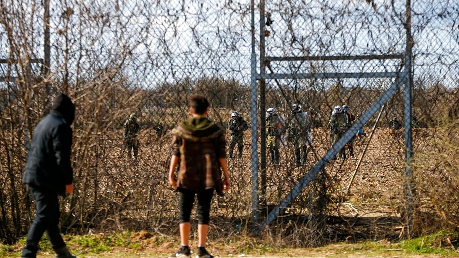 Migrants gather at a border fence on the Turkish side during clashes with the Greek riot police and army at the Turkish-Greek border.