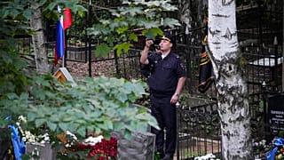 Rusya'daki Porokhovskoye mezarlığında düzenlenen cenaze töreninin ardından polis memuru, Wagner lideri Yevgeniy Prigojin'in mezarının fotoğrafını çekiyor,