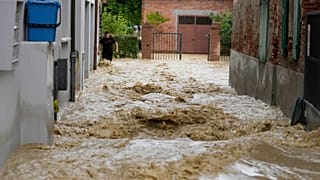 Un uomo cammina in una strada allagata nel paese di Castel Bolognese, Italia, mercoledì 17 maggio 2023\.