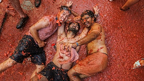 مشاركون غارقون في عصير الطماطم أثناء مهرجان لا توماتينا في إسبانيا ـ 2022