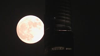 القمر الأزرق العملاق يضيء سماء دبي، فيما يظهر برج خليفة في الأفق