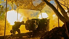 FILE - A Ukrainian serviceman of the 10th Assault Brigade Edelweiss fires a D-30 cannon towards Russian positions at the front line, near Bakhmut, Ukraine, July, 2023. 