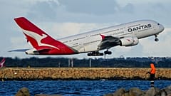 A Qantas A380 takes off from Sydney Airport over Botany Bay as a fisherman stands on breakwater in Sydney, Australia, Monday, Sept. 5, 2022.