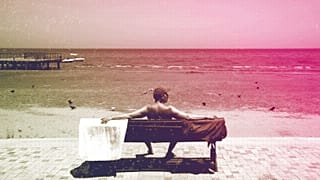 Un touriste est assis sur un banc à la plage de Finikoudes dans la ville côtière de Larnaca, mai 2022.