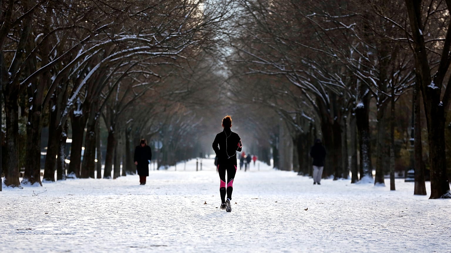 Una mujer corre por un callejón cubierto de nieve, en París, el miércoles 10 de febrero de 2021.