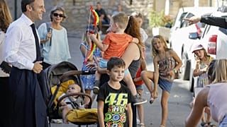 Президент Франции Эммануэль Макрон (слева)  с жителями Бом-де-Вениз на юго-востоке страны 1 сентября 2023 года во время поездки, посвященной реформе профессиональных школ