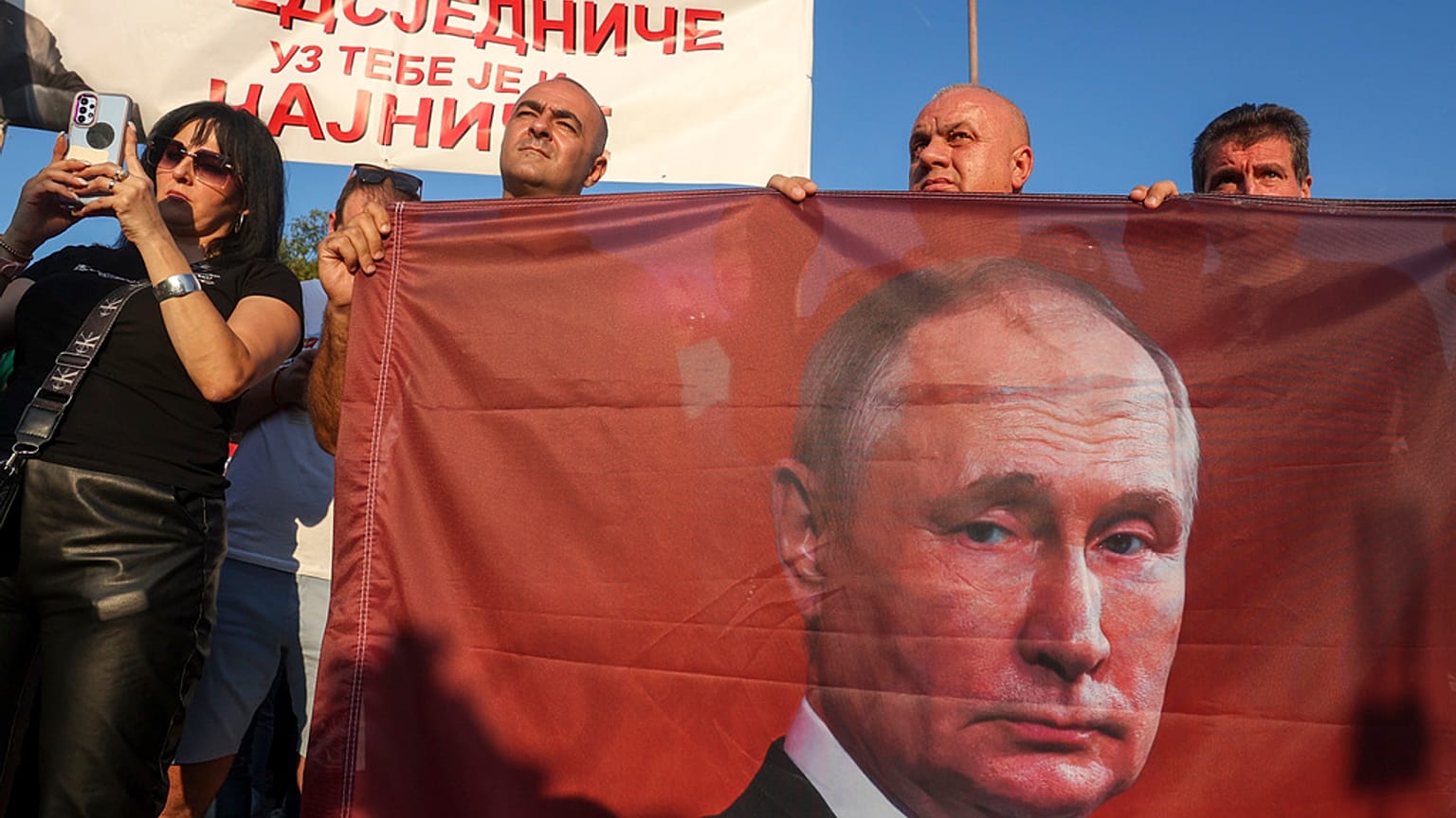 Protesters hold a flag showing Russian President Vladimir Putin during a rally supporting Milorad Dodik, pro-Russian leader in Bosnia, Lukavica, Bosnia, Friday, Sept. 1, 2023