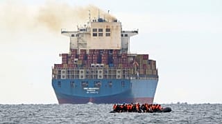 Migrants cross the Channel in a small boat traveling from the coast of France and heading in the direction of England on 29 August