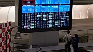 Visitors look at an electronic stock board at Tokyo Stock Exchange in Tokyo