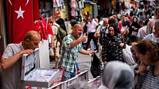 Venditori ambulanti assistono i clienti in un mercato di strada nel quartiere commerciale di Eminonu, a Istanbul, Turchia. (16 giugno 2023).