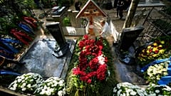 Женщина возлагает цветы на могилу главы группы компаний "Вагнер" Евгения Пригожина на Пороховском кладбище в Санкт-Петербурге, Россия, в среду, 30 августа 2023 года.