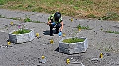 Сапёр осматривает территорию, над которой взорвался кассетный боеприпас