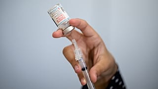 A member of the medical staff prepares a syringe with a vial of Moderna vaccine against Covid-19.