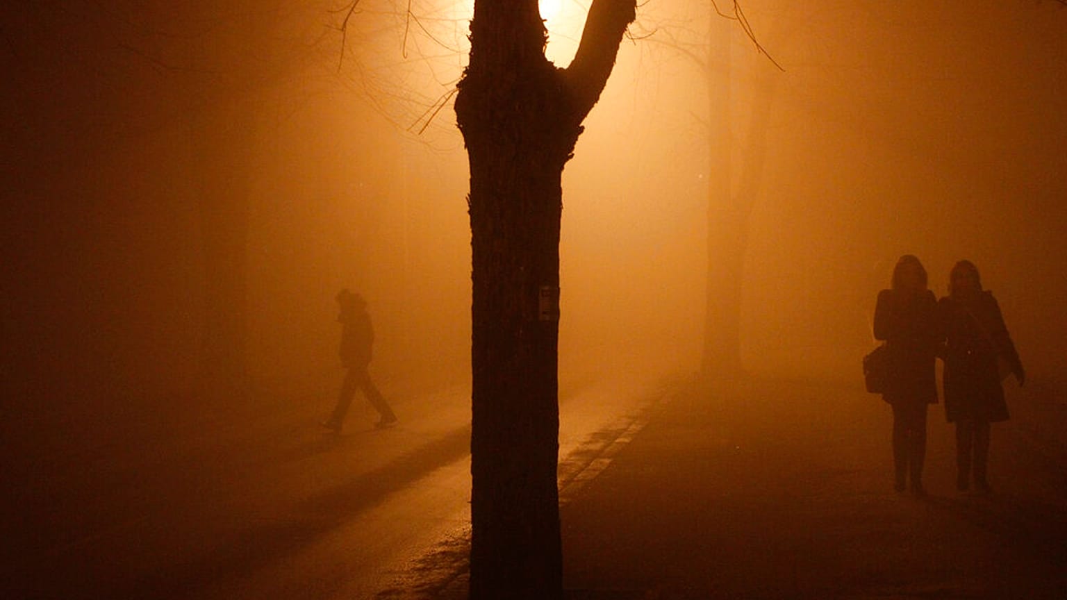    Bosnian people walking on the street during heavy smog in northern Bosnian town of Tuzla, 140 kms. north of Sarajevo, Monday, Dec. 16, 2013.