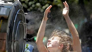 Eine Frau steht vor einer Ventilator im australischen Melbourne