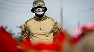 Um combatente da força militar privada Wagner está de pé num memorial informal junto ao antigo "PMC Wagner Centre" em São Petersburgo, Rússia, quinta-feira, 24 de agosto de 2023\.