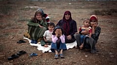 Köylerindeki şiddet olaylarından kaçan Suriyeli bir aile, Türkiye'nin Suriye sınırına yakın Atme köyündeki yerinden edilmişler kampında yerde oturuyor.