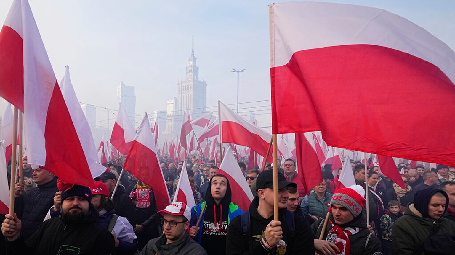 File - People hold Polish flags, during the annual Independence Day march in Warsaw, Poland, Thursday, Nov. 11, 2021. 