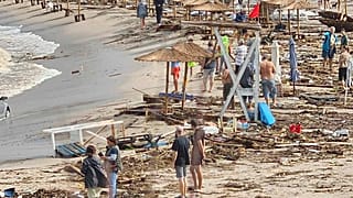 Menschen laufen zwischen zerstörten Gegenständen am Strand im bulgarischen Arapya nach den schweren Unwettern