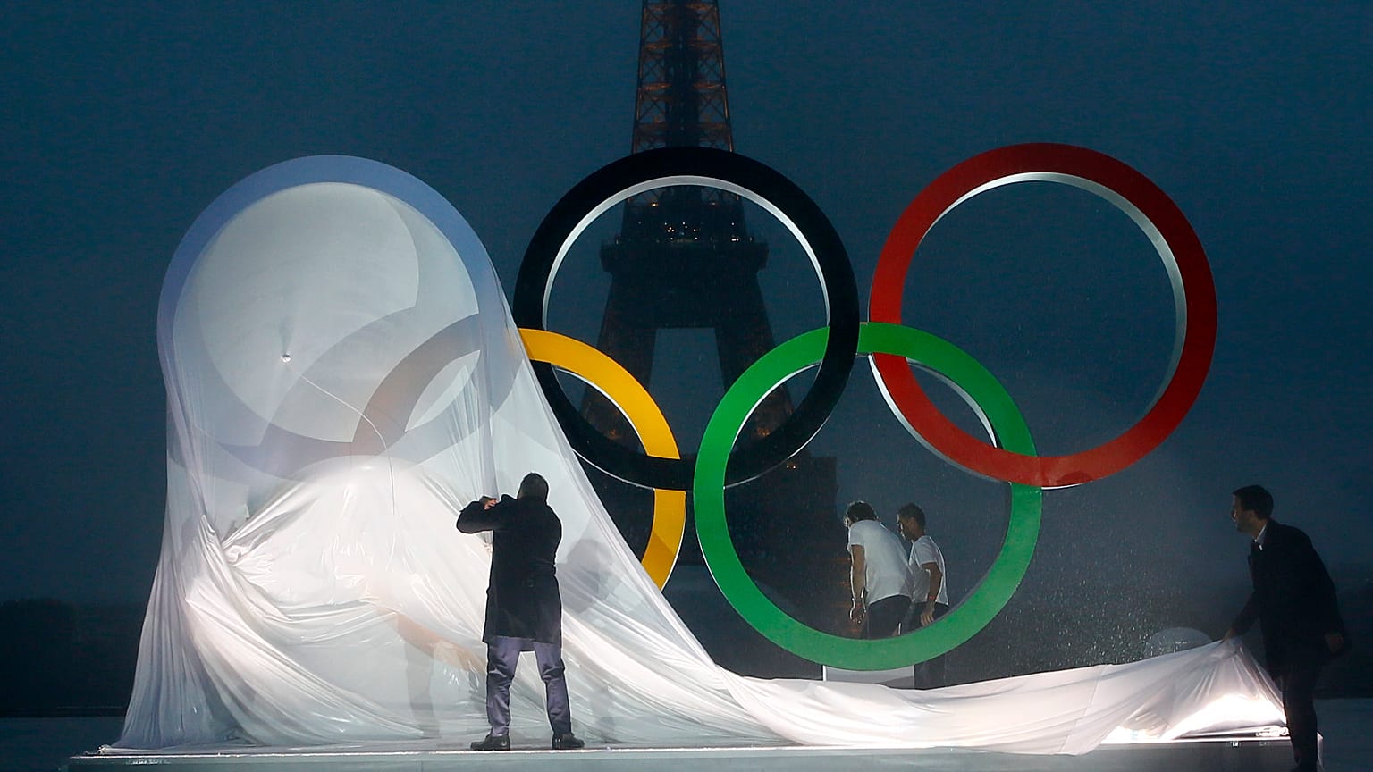 Paris officials unveil a display of the Olympic rings on Trocadero plaza that overlooks the Eiffel Tower in Paris, Wednesday, Sept. 13, 2017.