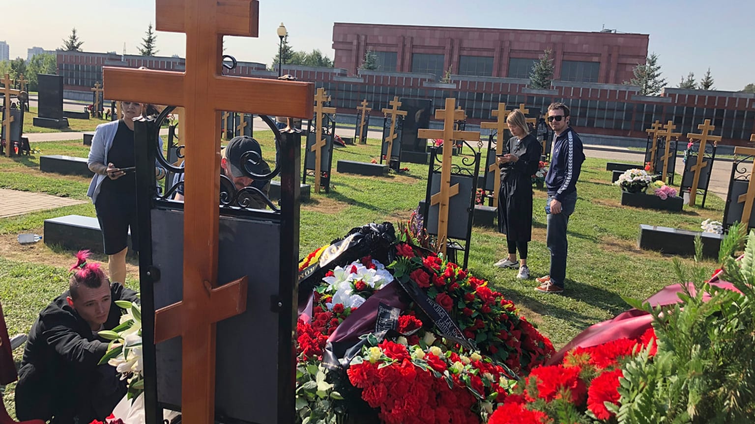 Journalists stand next to the grave of Dmitry Utkin, who oversaw Wagner Group's military operations, at the Federal Military Memorial Cemetery in Mytishchy, outside Moscow