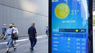 People walking past a weather report in Tower Bridge, London, England, Thursday Sept. 7, 2023 