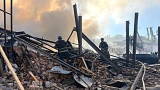 Emergency services personnel work to extinguish a fire following a Russian attack in Kryvyi Rih