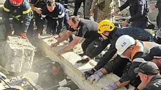 Сотрудники экстренных служб и полицейские вытаскивают раненого из-под завалов на месте российского ракетного удара, Кривой Рог, 8 сентября 2023 года.